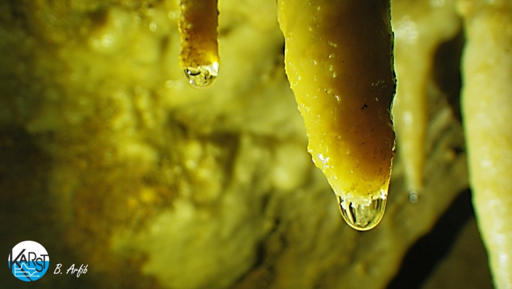 Stalactite pendant au plafond d’une grotte, avec sa goutte d’eau qui dépose petit à petit la calcite
